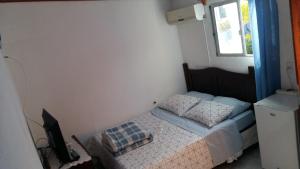 Dormitorio pequeño con cama y TV en Munaywasy monoambiente para dos, en Piriápolis