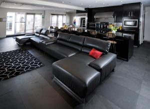 a living room with a leather couch and a bar at Posh South Beach in Miami Beach