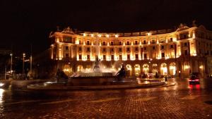 un edificio con una fontana di fronte ad esso di notte di Vatican Comfort Suites a Roma