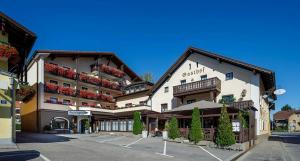 a large building with flowers on the balconies in a parking lot at Hotel Pockinger Hof in Pocking