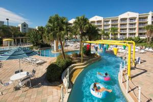 un tobogán de agua en un complejo con gente en él en Cape Canaveral Beach Resort en Cape Canaveral