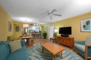 a living room with a blue couch and a tv at Cape Canaveral Beach Resort in Cape Canaveral