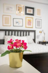 a vase with pink flowers on a table in a bedroom at Travel & Live Porto Hostel in Porto