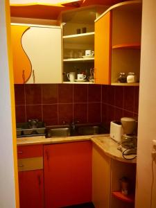 une cuisine avec des armoires jaune et rouge et un évier dans l'établissement Nexus Holiday, à Miercurea-Ciuc