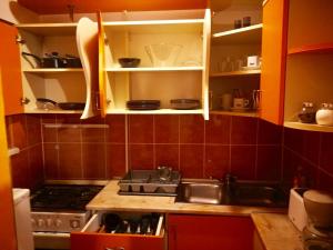 eine Küche mit roten Schränken, einem Herd und einer Spüle in der Unterkunft Nexus Holiday in Miercurea Ciuc