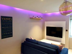 a living room with a blue couch and a tv at le cosy in Vannes