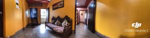 a living room with a couch in a yellow wall at 12 Homestay Apartments in Siliguri