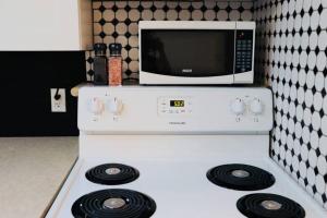 a microwave on top of a white stove in a kitchen at Sun Dog Manor in Maple Creek