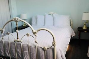 Schlafzimmer mit einem Bett mit weißer Bettwäsche und Kissen in der Unterkunft Sun Dog Manor in Maple Creek