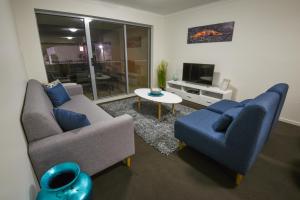 a living room filled with furniture and a tv at Direct Hotels - Breeze on Brightwater in Mooloolaba