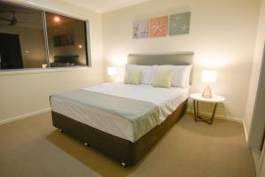a hotel room with a bed and a lamp at Direct Hotels - Breeze on Brightwater in Mooloolaba