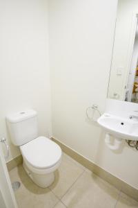 a white toilet sitting next to a white sink at Direct Hotels - Breeze on Brightwater in Mooloolaba