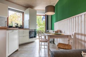 比苏姆Seehof Boutique Appartements的厨房配有桌子和绿色的墙壁