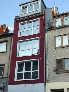 a red building with white windows on the side of it at Newtown Apartments Bremen in Bremen