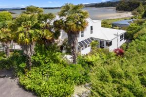 uma vista aérea de uma casa branca com palmeiras em BEACH FRONT:Palms-on-the-beach.KAITERITERI. em Kaiteriteri