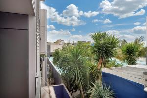 a balcony with palm trees and a swimming pool at QV Modern 3 Level Sunny Townhouse (640) in Auckland