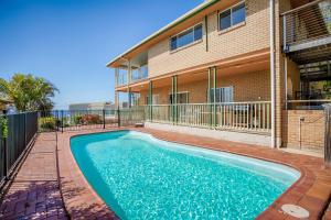 a swimming pool in front of a building at 100 Cooloola Drive in Rainbow Beach