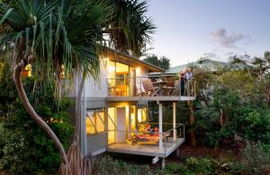 a house with people sitting on the balcony of it at The Retreat Beach Houses in Peregian Beach