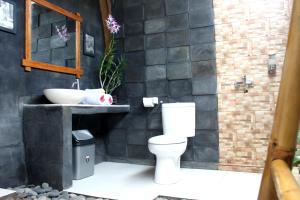 een badkamer met een wit toilet en een wastafel bij Morning Bali Bungalow in Canggu +39 foto's