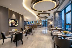 a restaurant with tables and chairs and a large chandelier at Ascott Songshan Lake Dongguan in Dongguan
