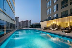 uma piscina ao lado de um edifício em Ascott Songshan Lake Dongguan em Dongguan