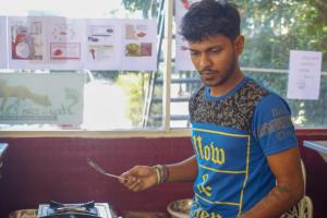 un hombre sosteniendo un cuchillo y un tenedor en un restaurante en Kandy Backpackers Hostel, en Kandy