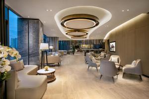 a lobby with a waiting room with couches and chairs at Ascott Songshan Lake Dongguan in Dongguan