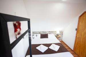 1 dormitorio con litera y paredes blancas en Tel Hauke Hostal en Punta Arenas