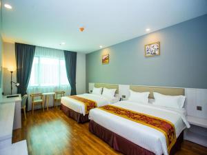 pokój hotelowy z 2 łóżkami i stołem w obiekcie Austin Park Hotel w mieście Johor Bahru