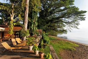 a group of benches sitting on a deck near the water at Walindi Plantation Resort in Kimbe