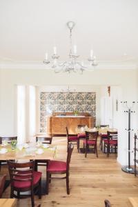 a dining room with tables and chairs and a piano at Altes Pfarrhaus in Geldern