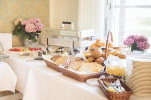 a table topped with baskets of bread and pastries at Altes Pfarrhaus in Geldern