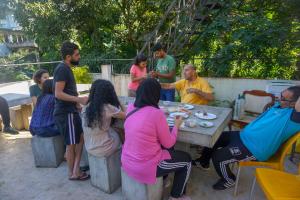 un grupo de personas sentadas alrededor de una mesa de picnic en Kandy Backpackers Hostel, en Kandy