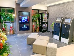 a lobby with two donation machines and a tv at HOTEL LiVEMAX Shinjuku Kabukicho in Tokyo