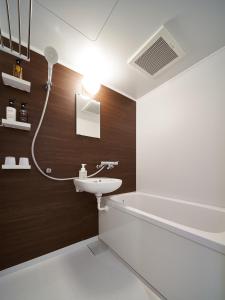 a bathroom with a sink and a bath tub at Carta Hotel Kyoto Bettei in Kyoto
