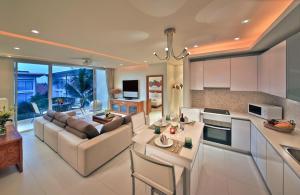 a kitchen and living room with a couch and a table at Chi Samui Resort in Bophut