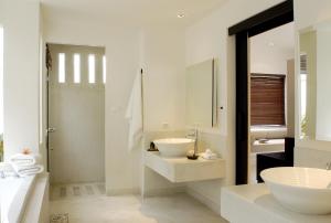 a white bathroom with a sink and a mirror at The Racha - SHA Extra Plus in Ko Racha Yai