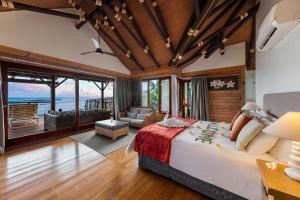 a bedroom with a large bed and a living room at Aga Reef Resort and Spa in Lalomanu