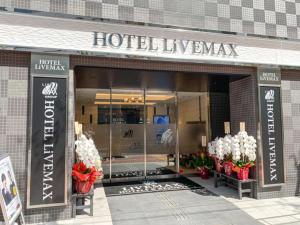 a hotel luxembourg entrance to a building with flowers at HOTEL LiVEMAX Nihonbashi Koamicho in Tokyo
