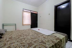 a bedroom with a bed with a brown and white blanket at Cempaka Hotel in Yogyakarta