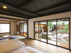Schlafzimmer mit großen Fenstern, einem Bett und Aussicht in der Unterkunft NIPPONIA HOTEL Takehara Saltworks Town in Takehara