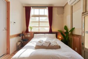 a bedroom with a bed with two towels on it at The Railway Hotel Koyasan Pilgrimage Railway - Station Inn - Self Check-in Only in Kudoyama
