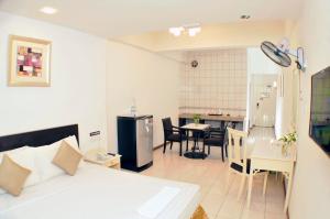 a room with a bed and a kitchen with a table at Promenade Service Apartment in Kota Kinabalu