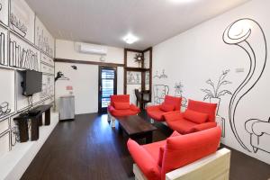 a living room with red chairs and a tv at Winsor's Han-Guan in Jiufen