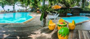 a swimming pool with chairs and a table and a chair at The Sunset Village -SHA PLUS CERTIFIED in Na Jomtien