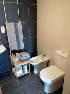a bathroom with a white toilet and a sink at Apartamentos MonteBlanco Costa da Morte in Neaño