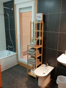 a bathroom with a toilet and a sink and a mirror at Apartamentos MonteBlanco Costa da Morte in Neaño