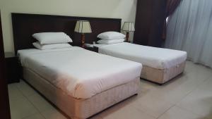 Rúm í herbergi á Al Muntazah Plaza Hotel