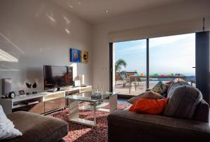 een woonkamer met een bank, een tv en een glazen tafel bij Villa Irene - Dream Seaview - by Holiday Rentals Villamar in Benitachell