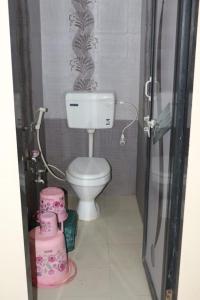 a small bathroom with a toilet and a shower at Hotel Laxmi Sadan in Somnath